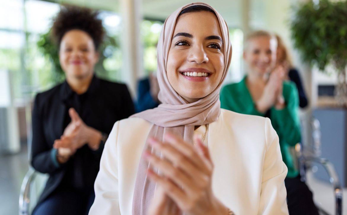 Islamic businesswoman clapping hands in a seminar