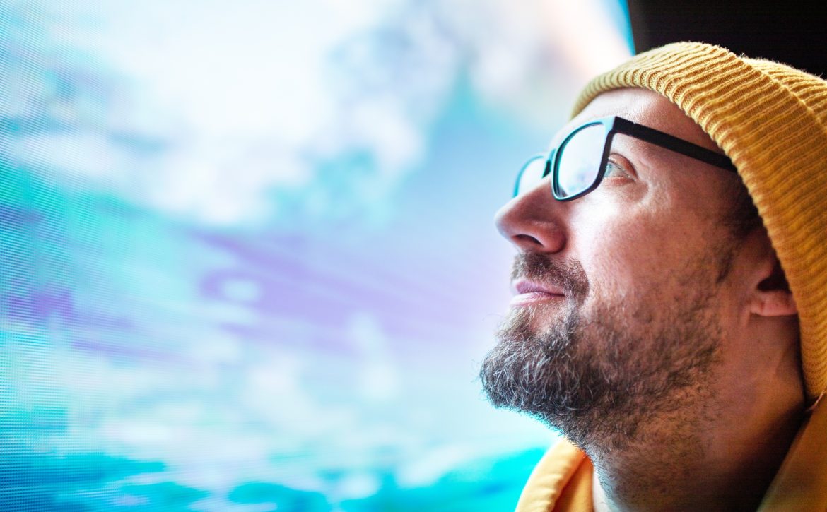 Closeup mid adult man portrait looking at neon light billboard at night at the city street