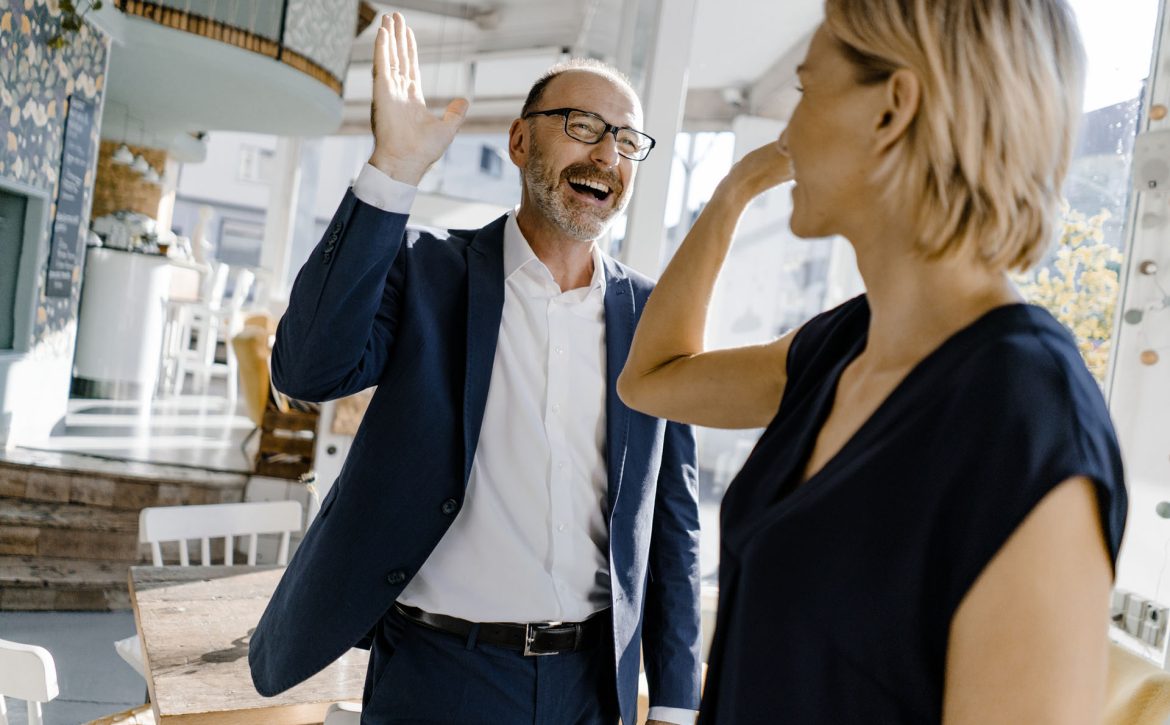 Business people high fiving in a coffee shop