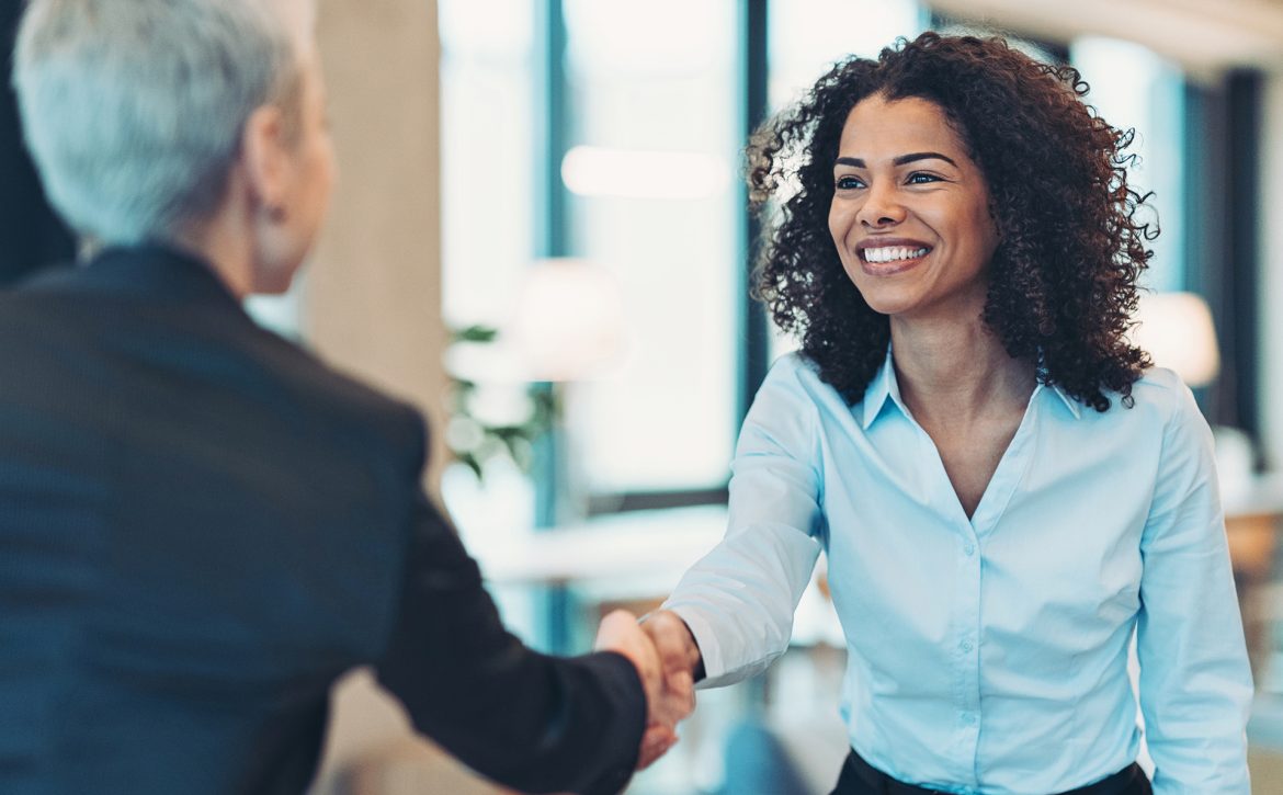 Smiling businesswoman greeting a colleague on a meeting