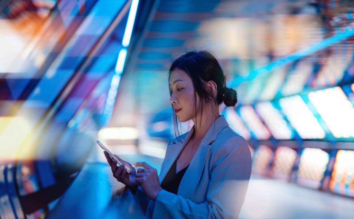 Young Asian business woman using smart phone in a Virtual Reality (VR) environment
